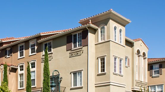 Mediterranean-style apartment building with blue sky.